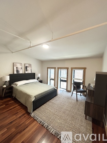 A bedroom with a bed, chair, and a piano.
