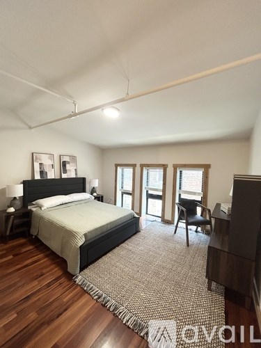 A bedroom with a bed, chair, and a piano.