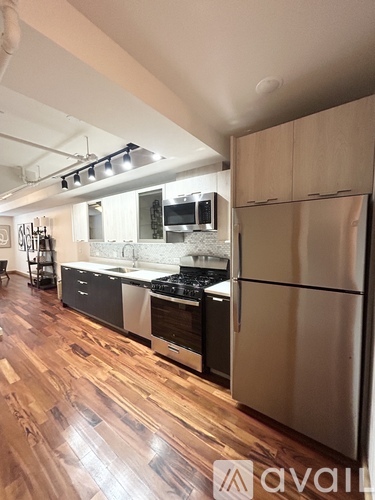 A kitchen with wooden floors and stainless steel appliances.