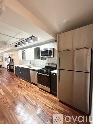 A kitchen with wooden floors and stainless steel appliances.
