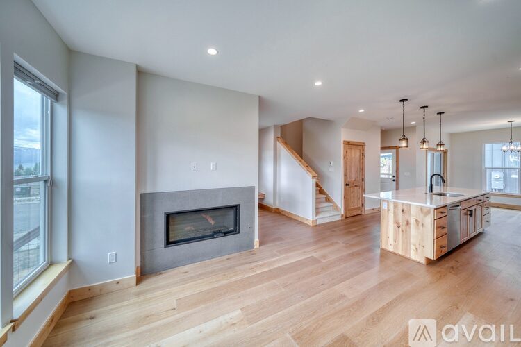 A modern living room with a fireplace and wooden floors.