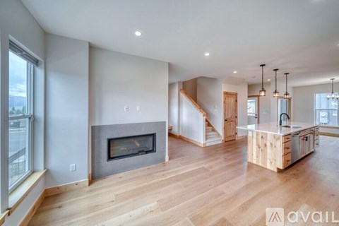A modern living room with a fireplace and wooden floors.