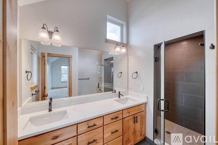 A bathroom with a sink, mirror, and wooden cabinets.