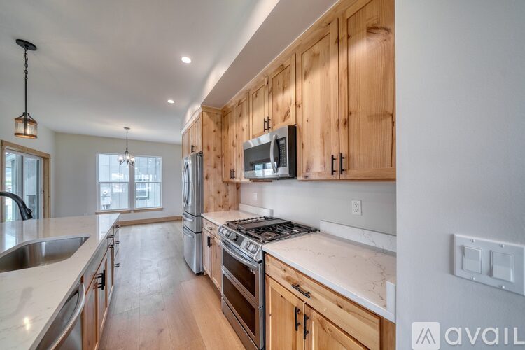 A kitchen with wooden cabinets and a stove top oven.