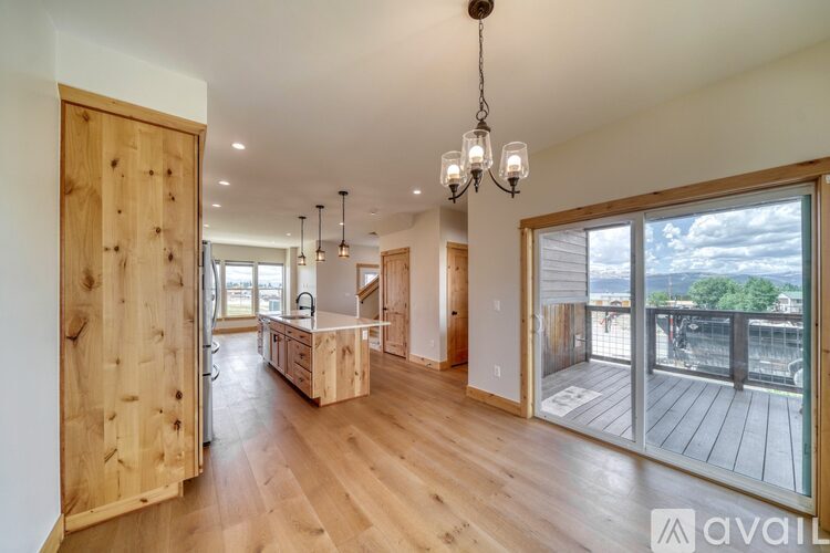A wooden door opens to a spacious room with a balcony.