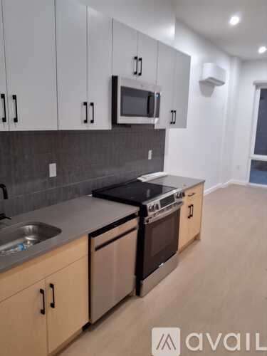 A kitchen with wooden cabinets and a black stove top oven.