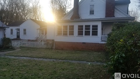 A house with a white picket fence is shown in the image.