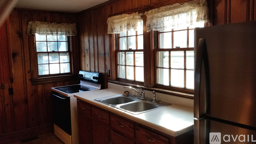 A kitchen with wooden cabinets and a stainless steel refrigerator.