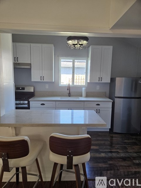 A kitchen with white cabinets and a marble countertop.