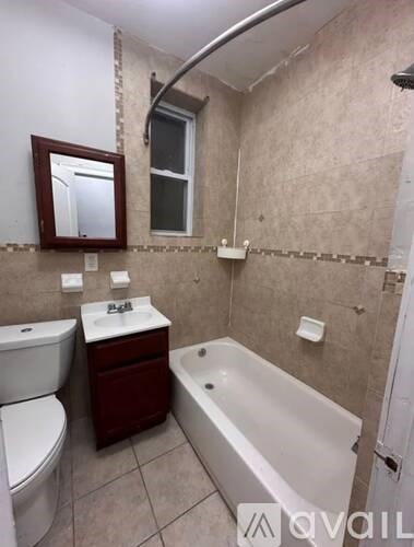 A bathroom with a toilet, sink, and bathtub.