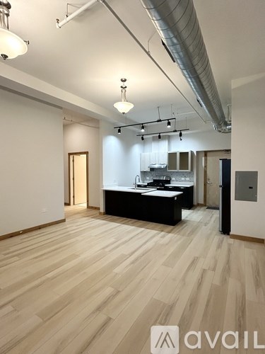 A room with wooden flooring and a white ceiling with a light fixture.