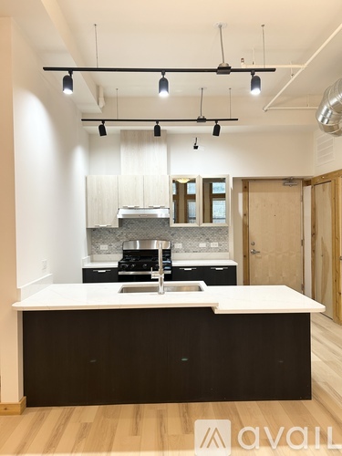 A modern kitchen with a white countertop and black cabinets.