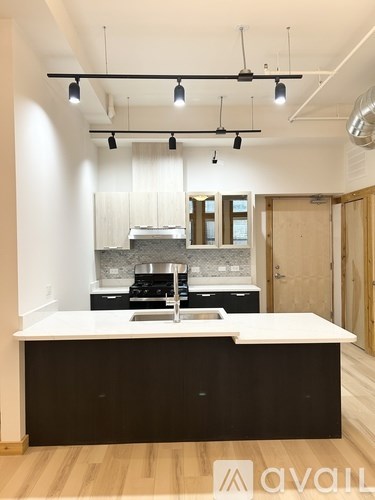 A modern kitchen with a white countertop and black cabinets.
