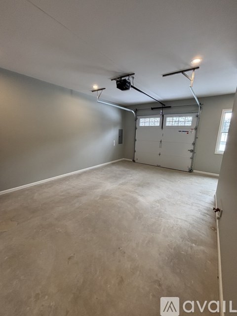 A spacious room with a garage door and a window.
