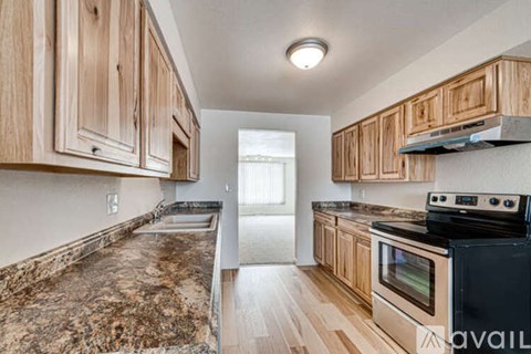 A kitchen with wooden cabinets and a black stove top oven.