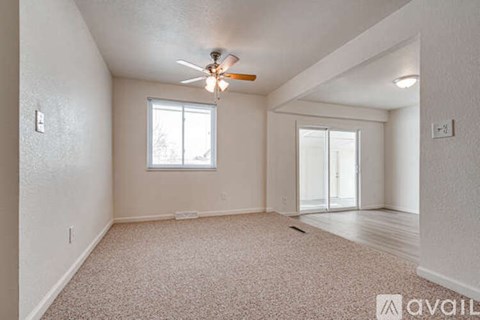 A room with a ceiling fan and a window.