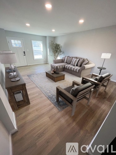 A living room with a grey sofa and wooden floors.
