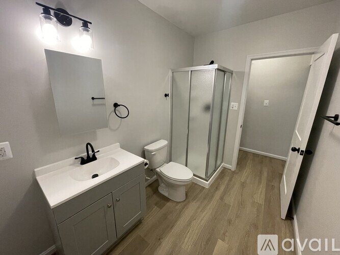 A bathroom with a sink, toilet, and shower stall.
