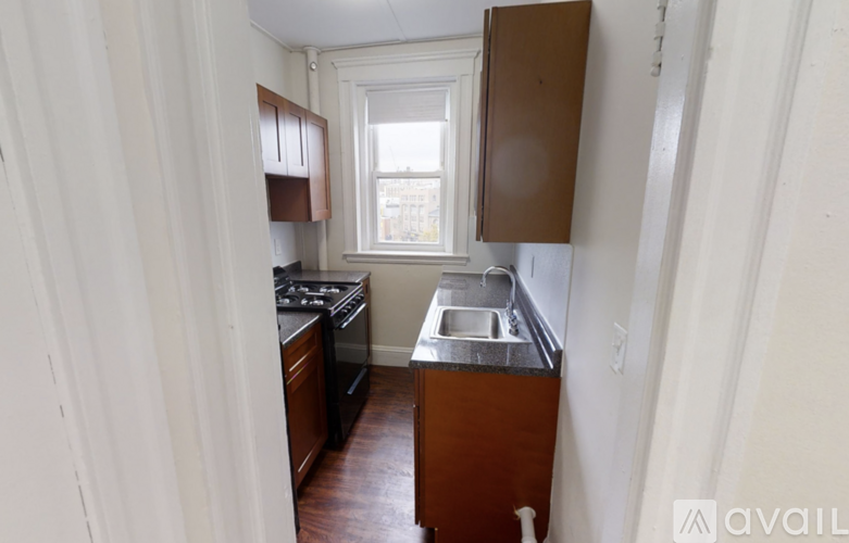 A kitchen with wooden cabinets and a window.