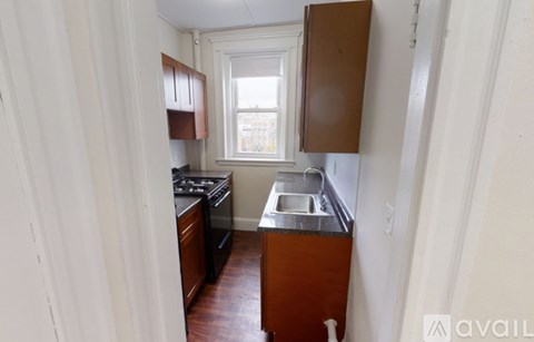 A kitchen with wooden cabinets and a window.