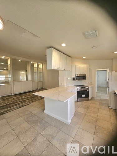 A kitchen with a white island in the middle of the room.