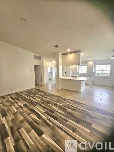 A room with wooden flooring and white walls.