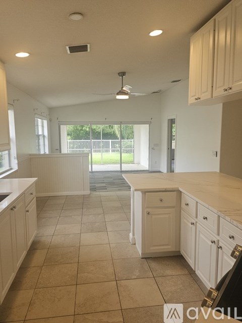 A kitchen with white cabinets and a tiled floor.