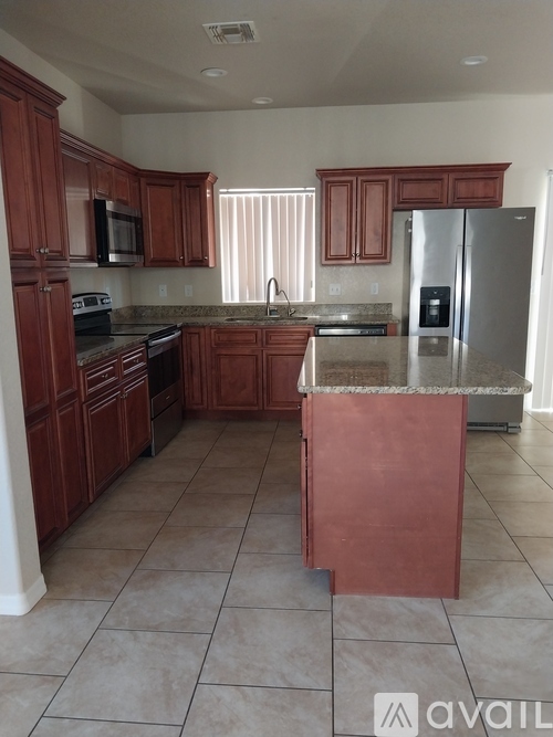 A kitchen with brown cabinets and a stainless steel refrigerator.