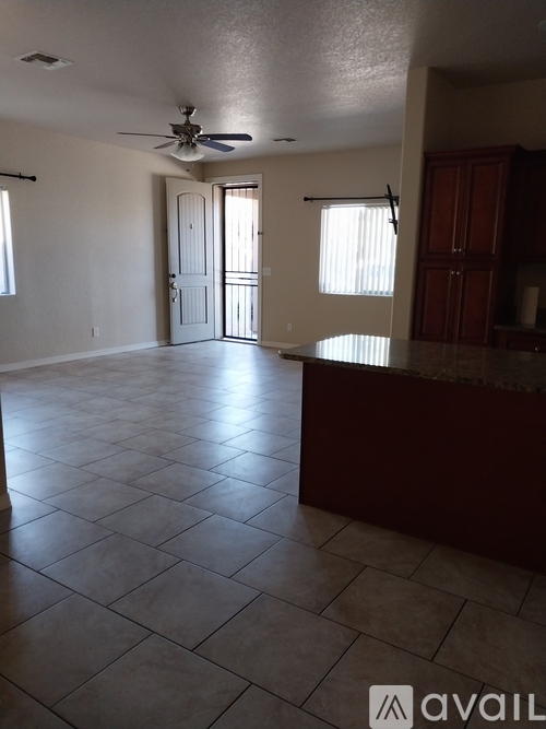 A spacious room with a ceiling fan and tiled flooring.