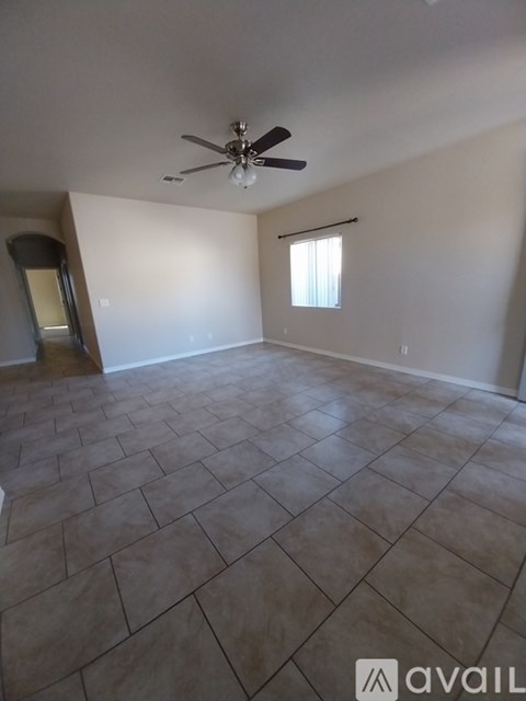 A room with a ceiling fan and a window.