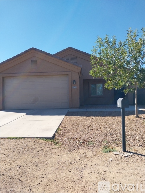 A house with a garage door and a tree in front.