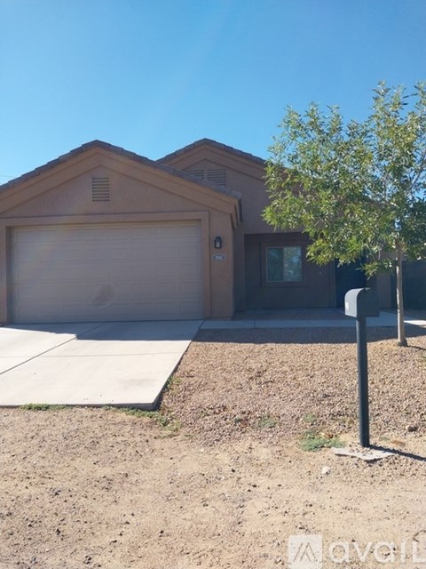 A house with a garage door and a tree in front.