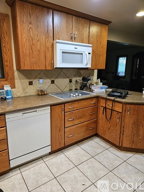 A kitchen with wooden cabinets and a white dishwasher.
