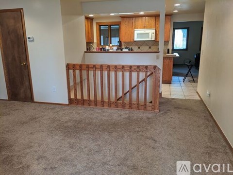 A carpeted room with a wooden gate in the middle.