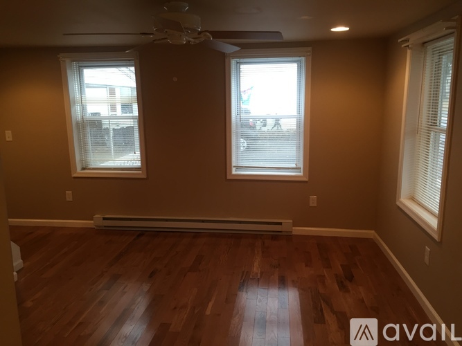 A room with wooden floors and two windows.