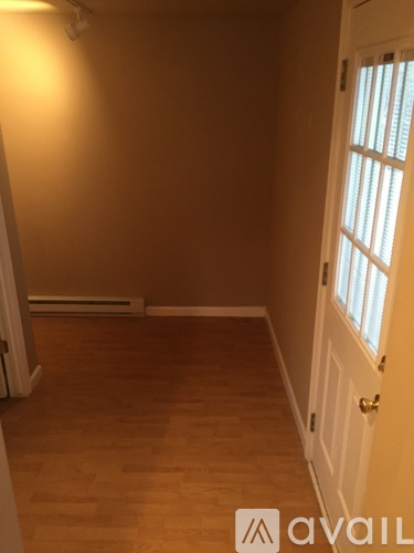 A room with wooden flooring and a white door.