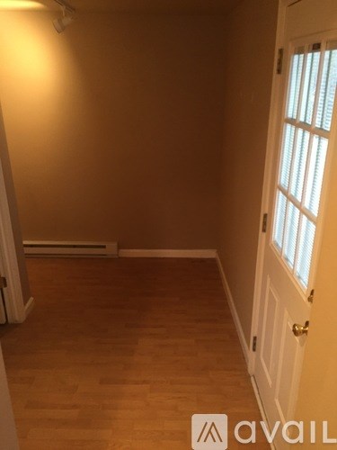 A room with wooden flooring and a white door.