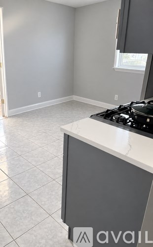 A kitchen with a stove top oven and a window.