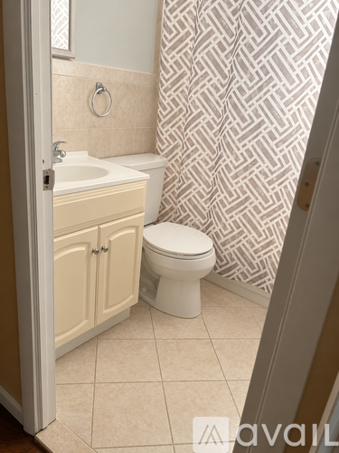 A bathroom with a toilet, sink, and shower curtain.