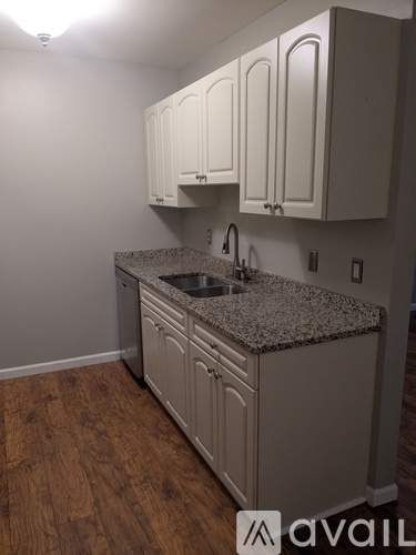 A kitchen with granite countertops and white cabinets.