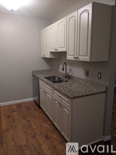 A kitchen with granite countertops and white cabinets.