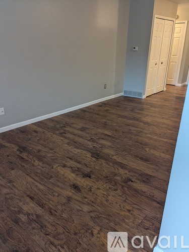 A room with wooden flooring and white walls.