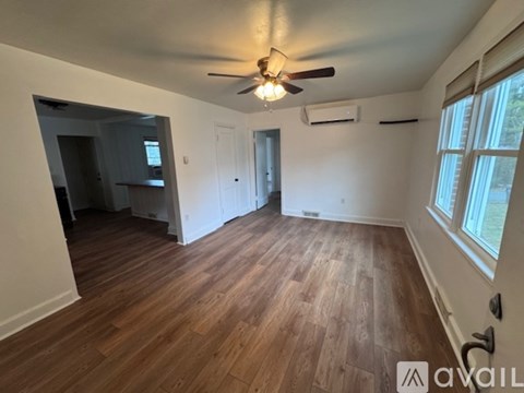 A room with wooden flooring and a ceiling fan.