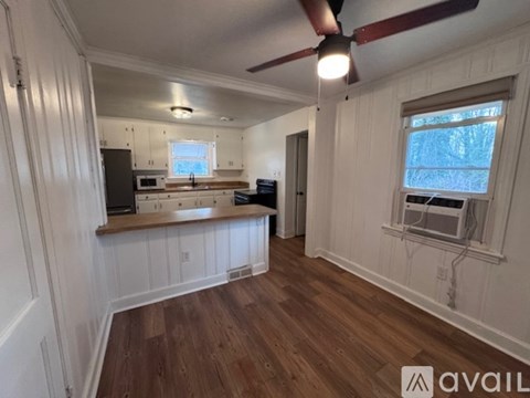 A room with wooden floors and a ceiling fan.