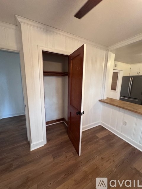 A room with a wooden floor and a door leading to another room.