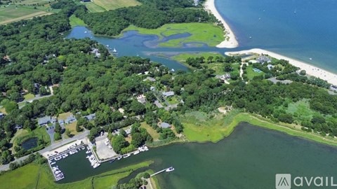 An aerial view of a coastal area with a marina and a sandy beach.