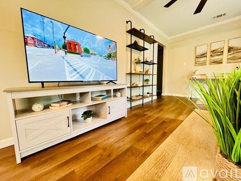 A modern living room with a flat screen TV mounted on the wall.