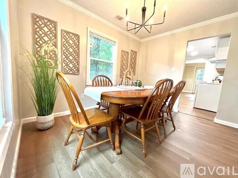 A dining room with a wooden table and chairs.