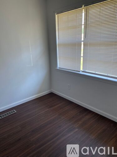 A room with a window and wooden flooring.