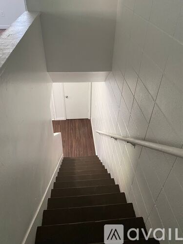 A staircase with white walls and wooden steps.